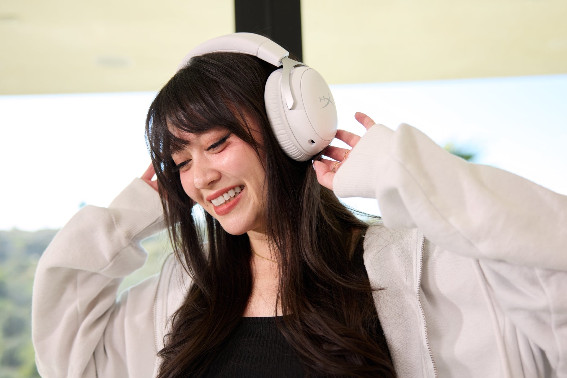 Femme portant un casque de jeu blanc et un manteau de couleur claire à l'intérieur